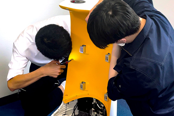 サービスロボットの内部を確認する技術者たち